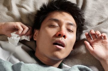 A male Chinese man is sleeping while catching cold and breathing